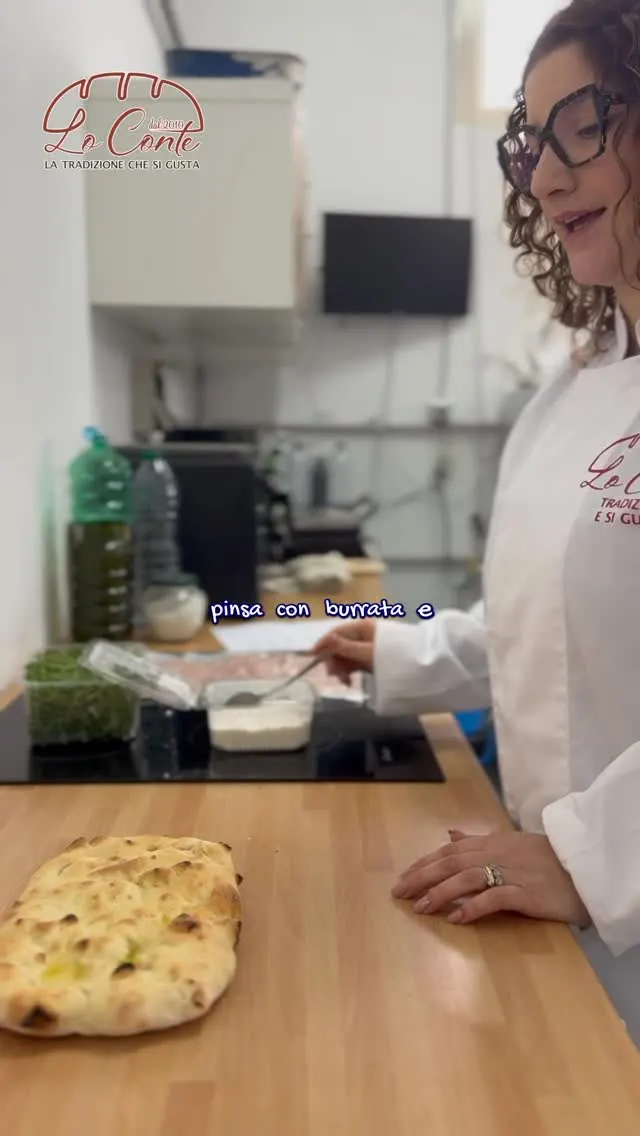 Pinsa appena sfornata sul tagliere, pronta per essere farcita con burrata e mortadella