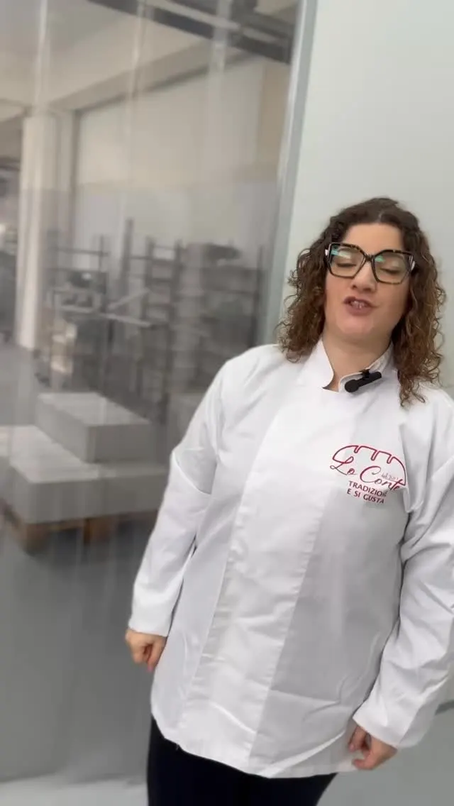La cuoca di Forno Lo Conte, in giacca bianca, racconta le fasi della produzione nel laboratorio