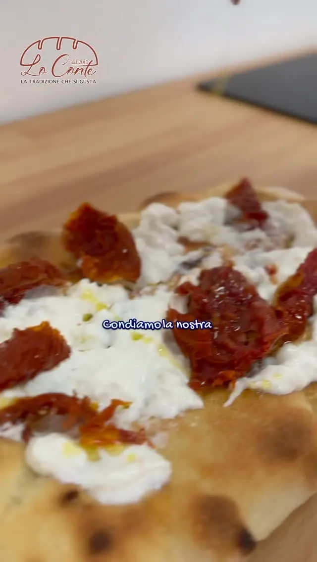Pinsa appena condita con burrata fresca e pomodorini secchi sott’olio